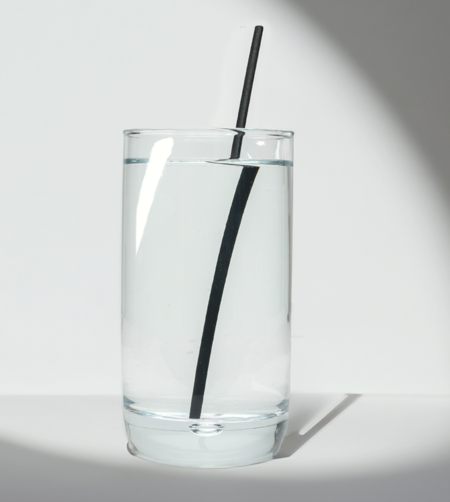 8-inch Black Long Sipper hemp straw in a glass of water