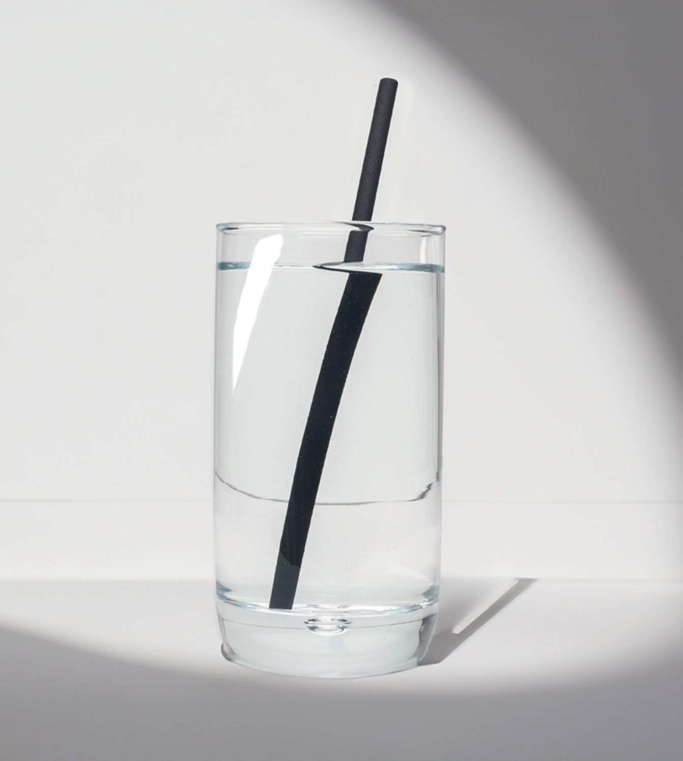 8-inch black compostable hemp straw in a glass of water